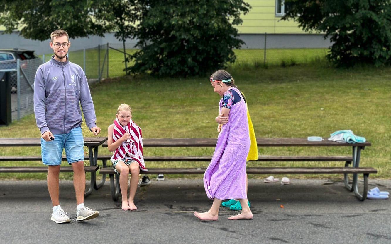 Fritidsledare Niclas Gustavsson med Maximilian Laxström Karlsson och Talia Ansofy Rageef. Barnen huttrar, det är 25 grader i vattnet och cirka 18 grader i luften den här förmiddagen.